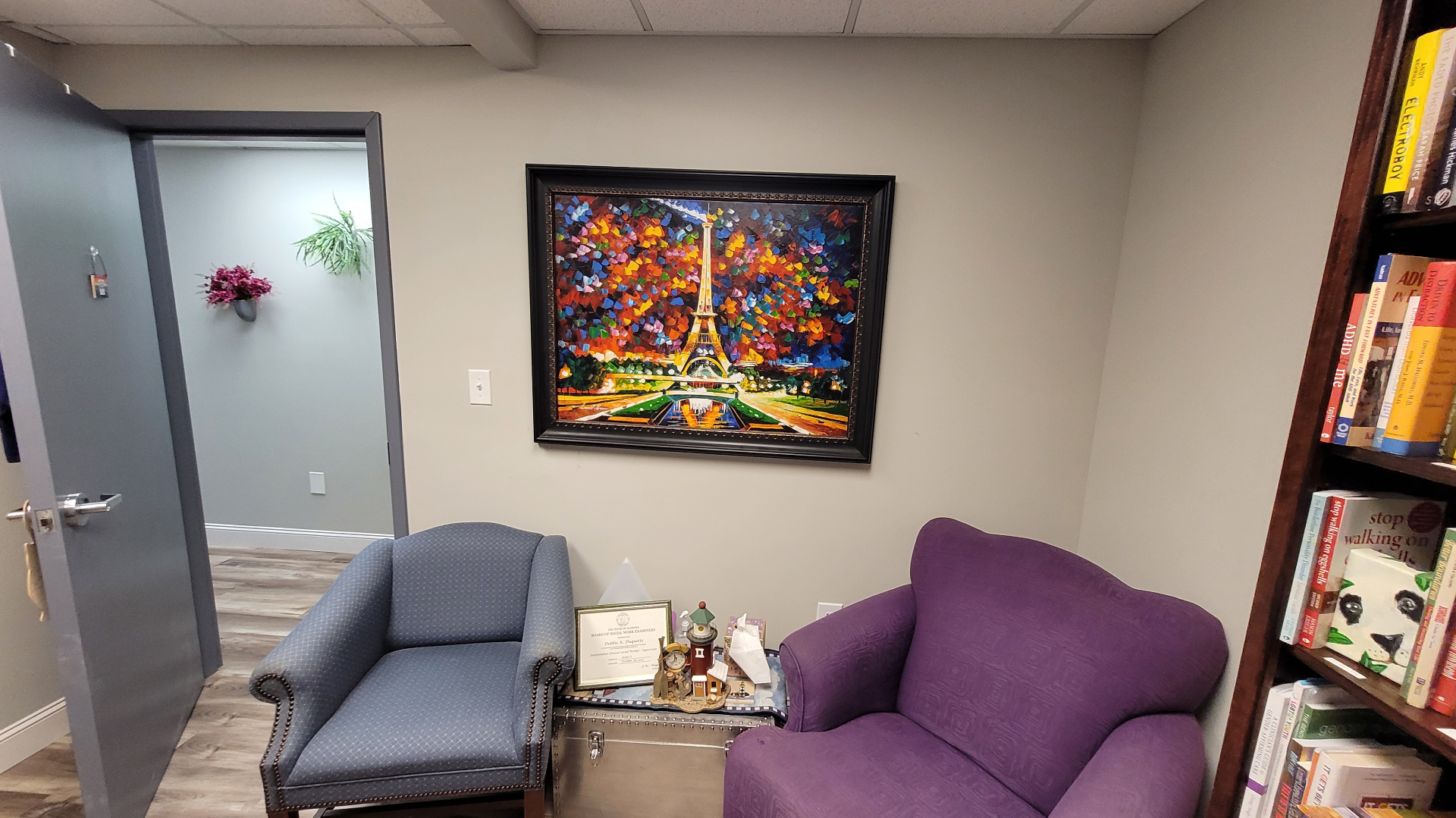 photo of office with neutral wall color, blue easy chair, large purple easy chair, and a colorful paintingbright painting,